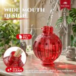 A vibrant red glass hummingbird feeder by Grete Gotye, hanging outdoors with five metal flower feeding ports.