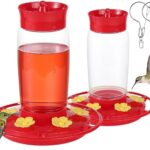 Two red Hpewi plastic hummingbird feeders with yellow flower feeding ports and ant moats, hanging outdoors.