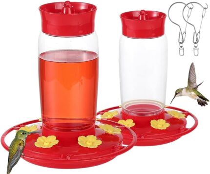Two red Hpewi plastic hummingbird feeders with yellow flower feeding ports and ant moats, hanging outdoors.
