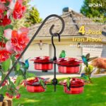 Four iBorn mini hummingbird feeders with red silicone flower feeding ports, hanging outdoors with a hummingbird nearby.