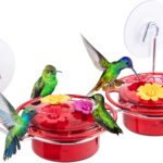 A vibrant red iBorn window hummingbird feeder with clear nectar reservoir, attached to a window pane via a large suction cup,