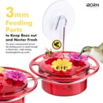 A vibrant red iBorn window hummingbird feeder with clear nectar reservoir, attached to a window pane via a large suction cup,