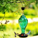 A vibrant blue hand-blown glass hummingbird feeder with five metal flower feeding ports and a built-in ant moat, hanging outd