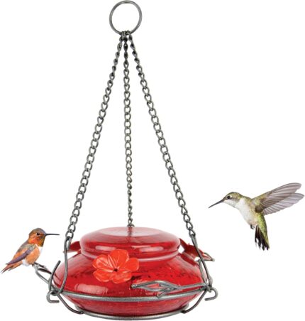 A vibrant red, hand-blown glass hummingbird feeder with a decorative hanging basket and three feeding ports.