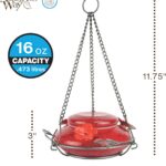 A vibrant red, hand-blown glass hummingbird feeder with a decorative hanging basket and three feeding ports.