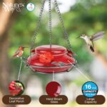 A vibrant red, hand-blown glass hummingbird feeder with a decorative hanging basket and three feeding ports.