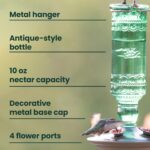Perky-Pet Antique Green Glass Hummingbird Feeder with a brushed nickel base and four flower-shaped feeding ports, hanging out